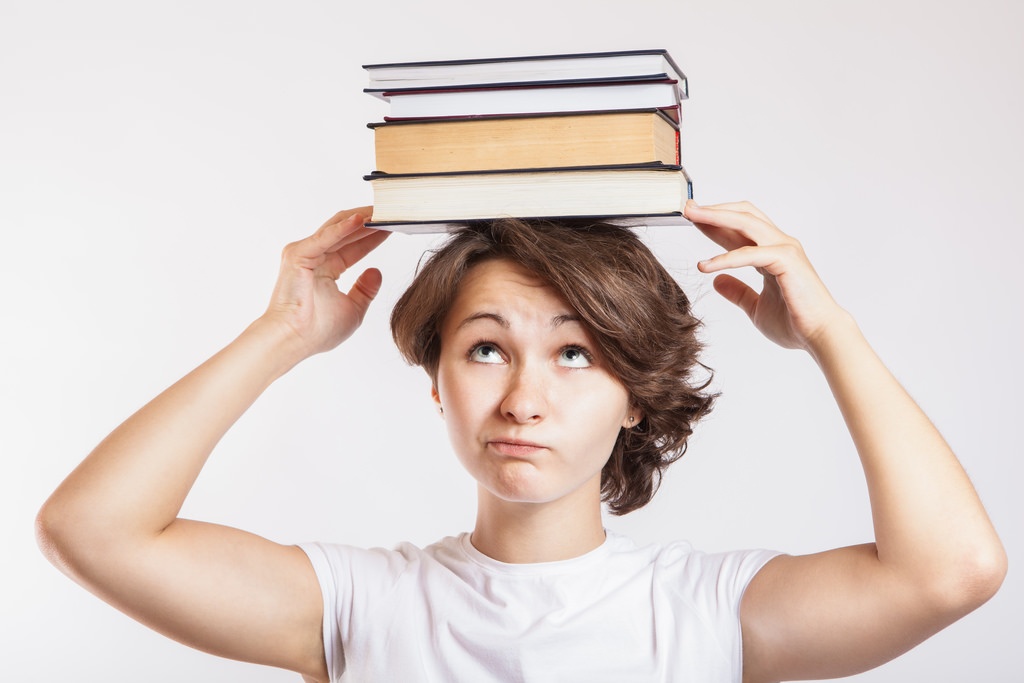 "Schoolgirl with books on head" by CollegeDegrees360, see description